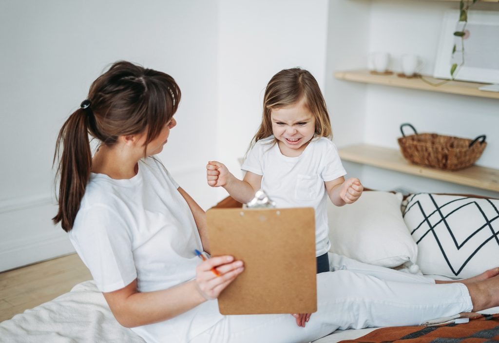 Mother and daughter playing, girl is angry, she lives negative emotions. Children's psychological educational games